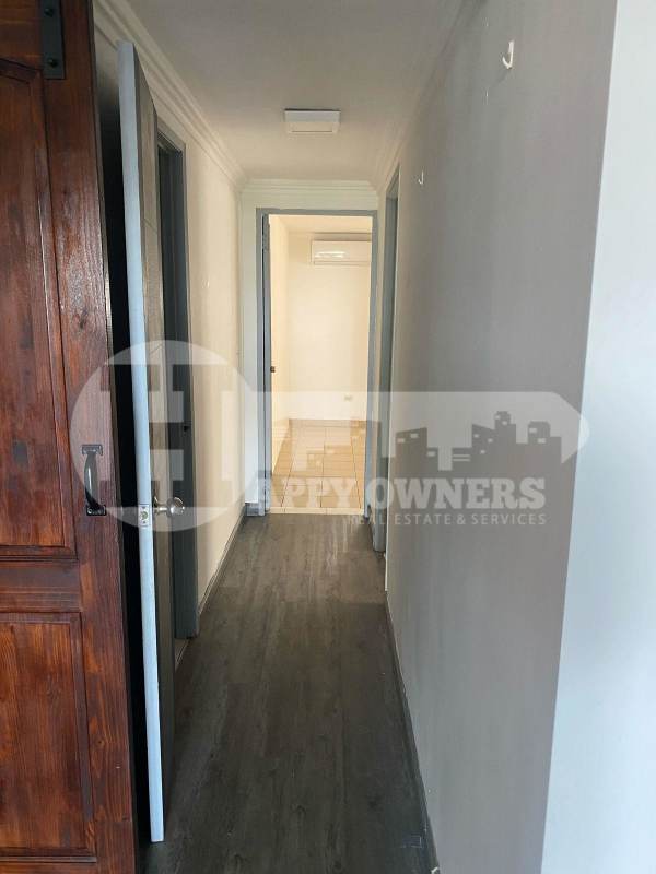 Hallway with gray flooring and wooden door in PH Lomas Carrasquilla Panama City