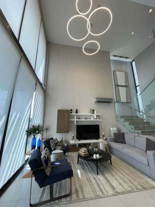 Spacious living room with tall windows, modern chandelier and natural light in Panama Norte luxury home