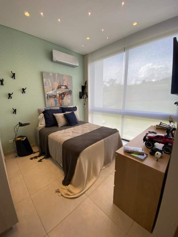 Bright bedroom with green accent wall and large window in Panama Norte luxury home