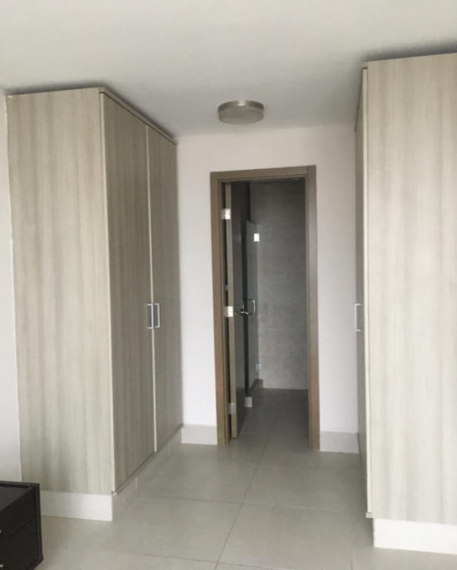 Spacious walk-in closet with built-in wood wardrobes and tile flooring Obarrio Panama