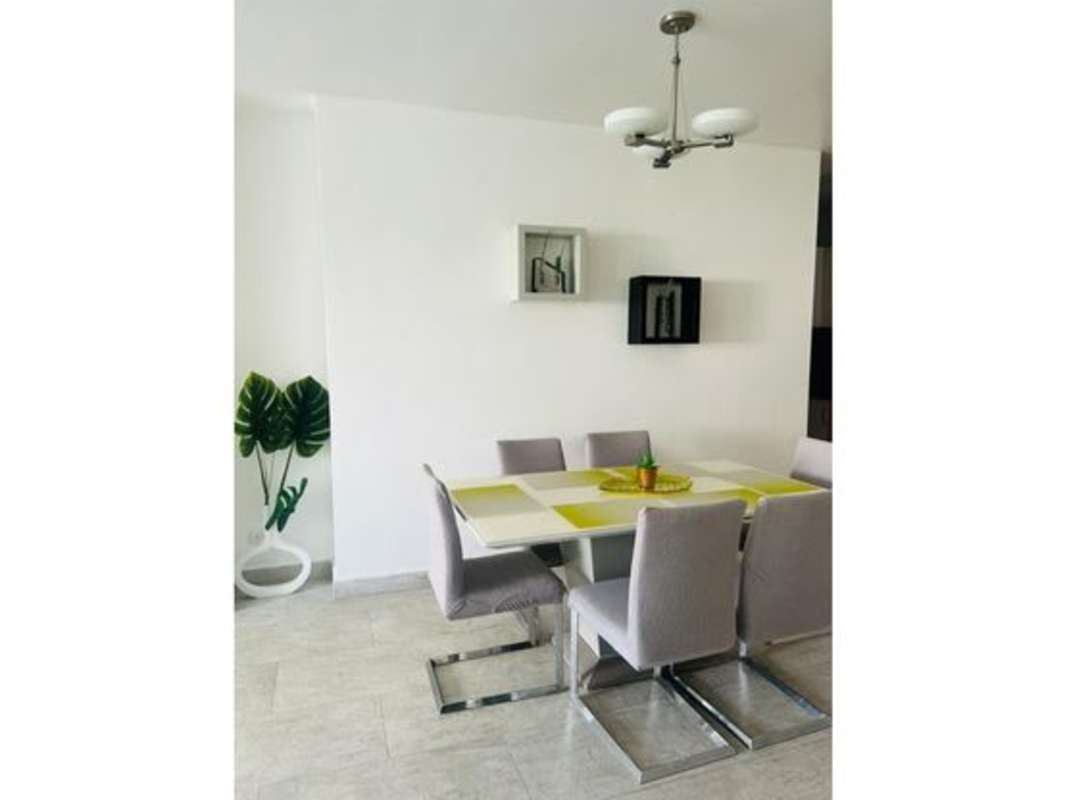 Dining area with gray chairs, white table, minimalist style PH Terramar Panama City