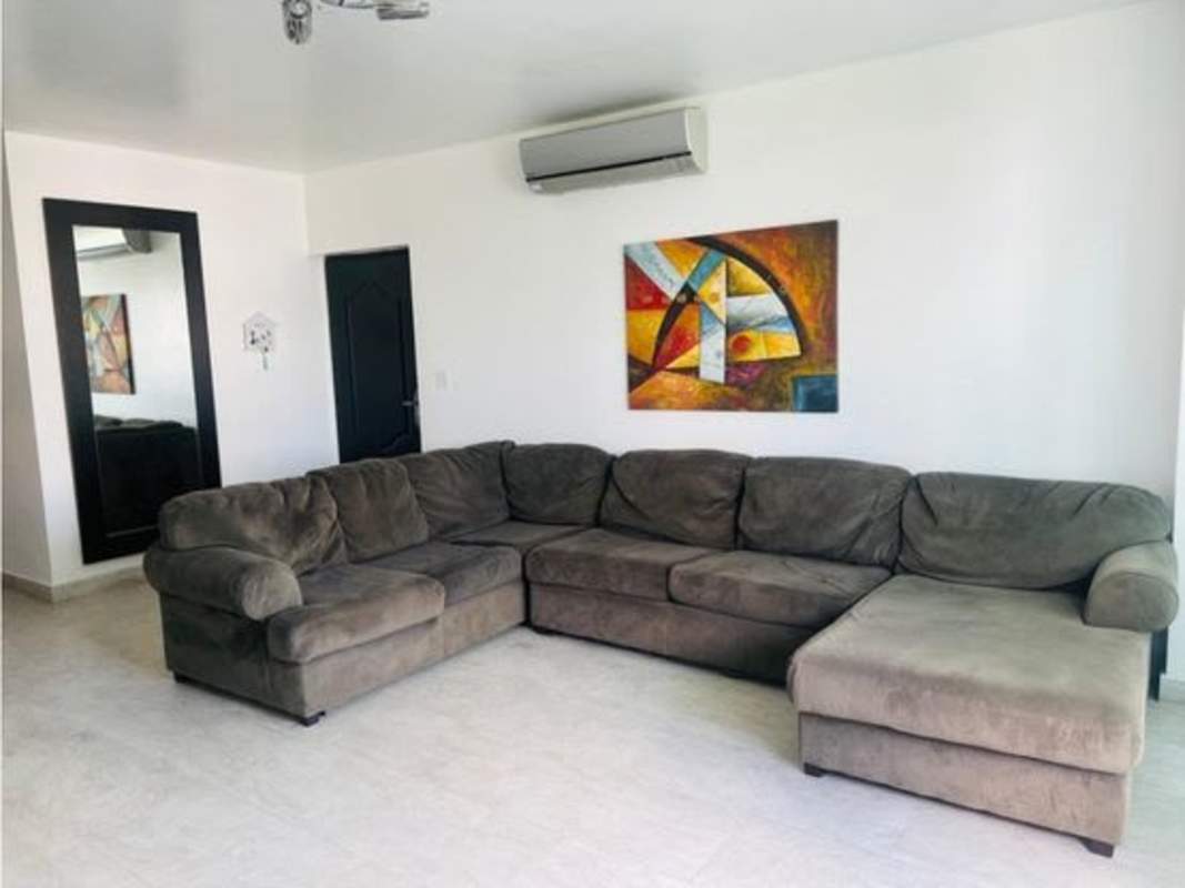 Spacious living room with large sectional sofa, wall art, modern decor PH Terramar Panama City