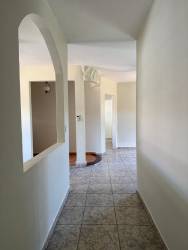 Interior hallway with arch detail, neutral tiles and walls at Villa Laura David Panama