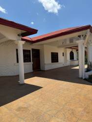 Exterior with Mediterranean-style red roof, white columns and paved area at Villa Laura David