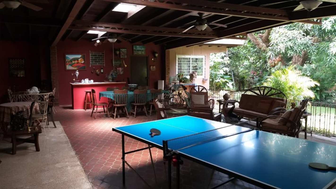 Traditional living room with exposed wood beams, tile flooring and cozy seating in estate home