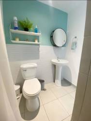 Minimalist bathroom with turquoise accent, pedestal sink, mirror PH Valle del Río Panama Oeste