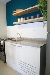 Compact granite kitchen, blue accent wall, round dining table PH Valle del Río Panama Oeste