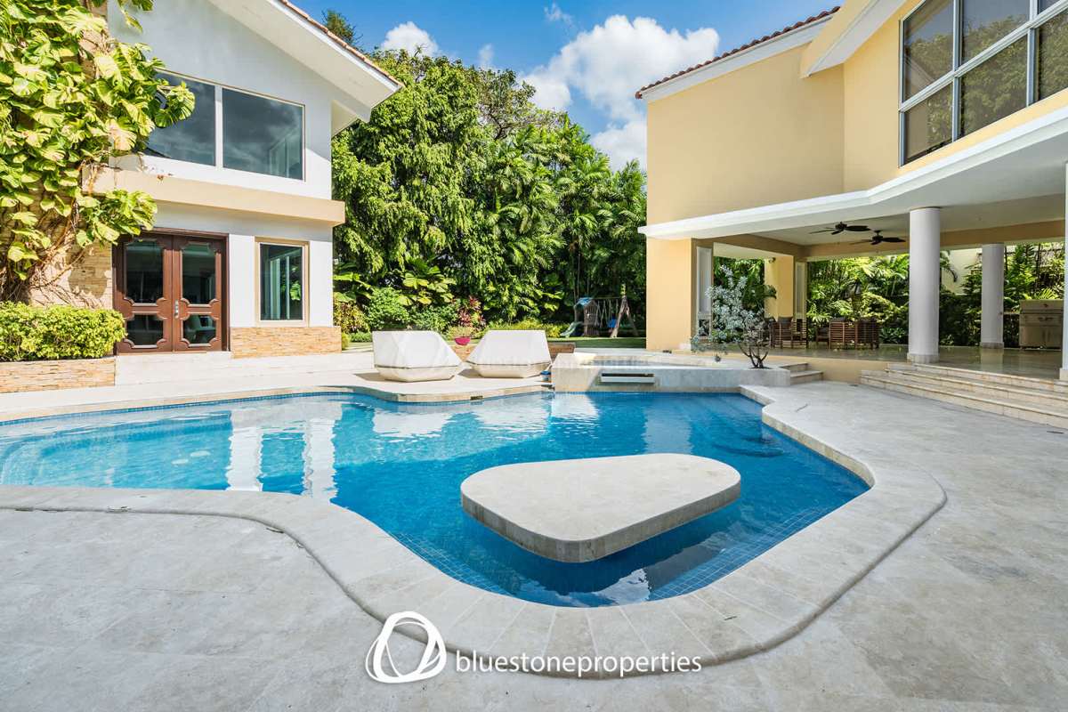 Spacious tropical backyard with swimming pool, sun loungers, and covered patio in Altos del Golf Panama City