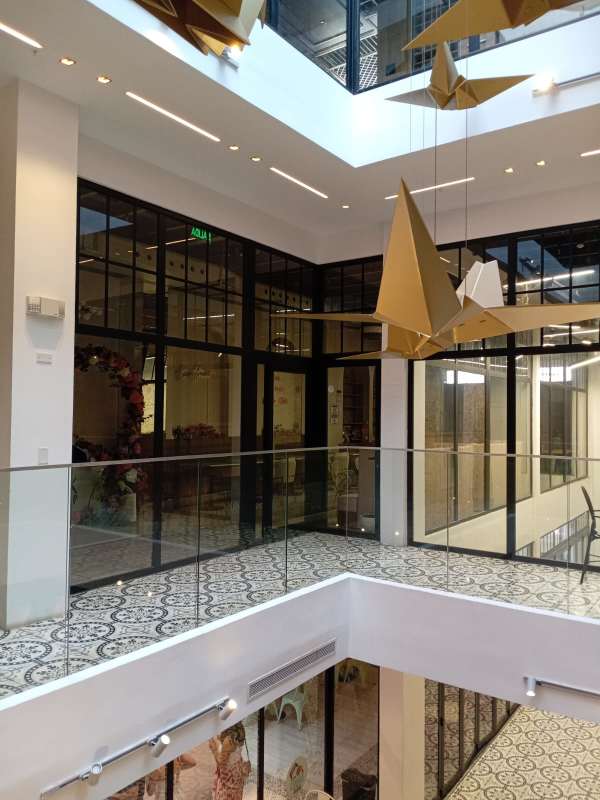 Contemporary designed indoor atrium in Casco Viejo commercial space with skylight and gold hanging sculptures