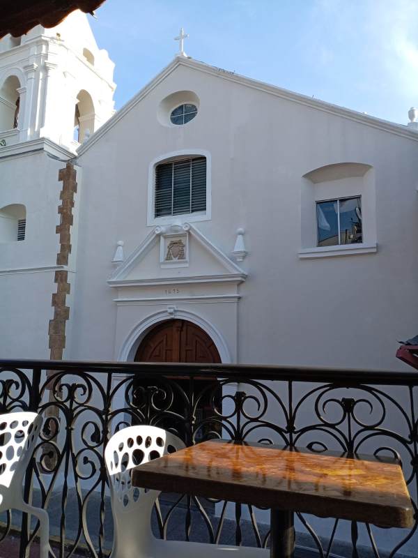 Balcony with colonial tiles overlooking historic church facade in Casco Viejo Panama City