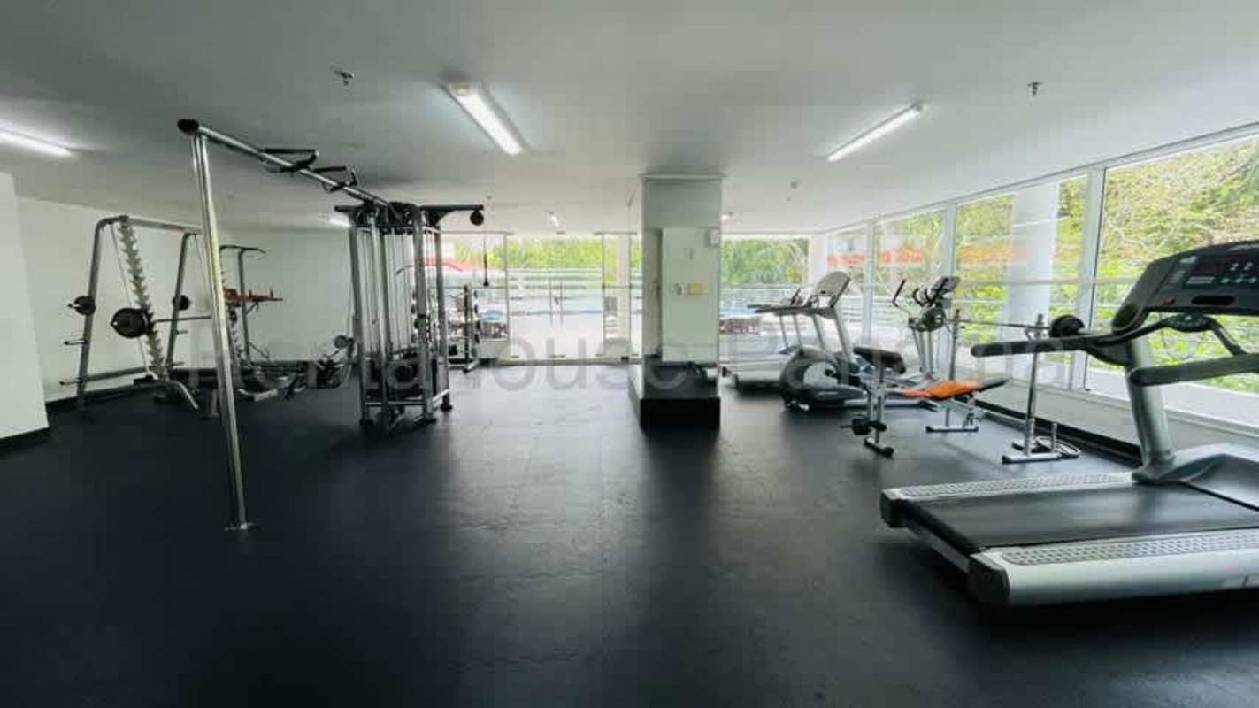 Living area with sliding doors opening to balcony with lush green view at Clayton Park Panama