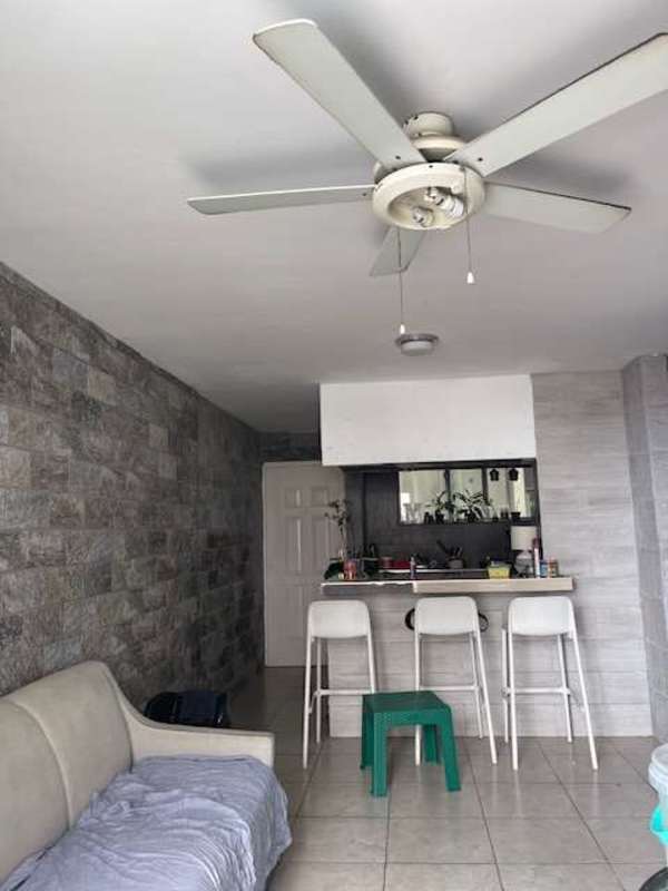 Living room with ceiling fan, stone accent wall and breakfast bar at PH Mystic Tower Panama City