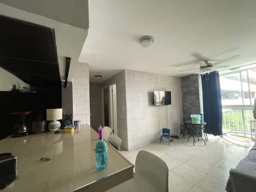 Living area with mounted TV, large windows, stone accent wall, in PH Mystic Tower Vía España Panama