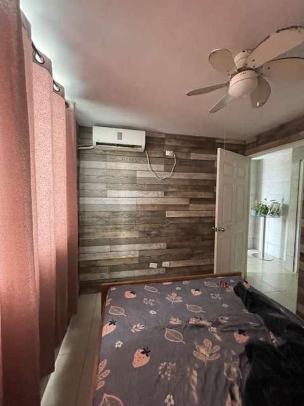 Bedroom with rustic accent wall, closet, fan and AC unit in PH Mystic Tower Panama City