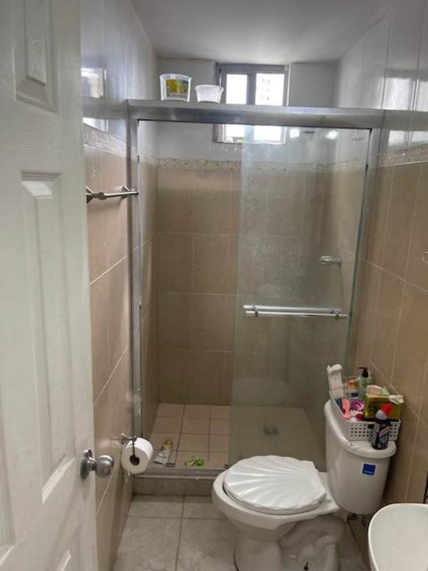 Bathroom with glass shower enclosure, pedestal sink and wall tiles in PH Mystic Tower