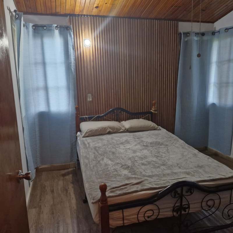 Rustic bedroom with wooden ceilings and accent wall mountain house Cerro Azul Panama