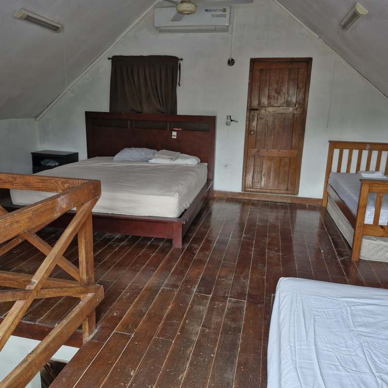 Loft bedroom featuring wooden floors, multiple beds under vaulted ceiling in mountain villa Cerro Azul