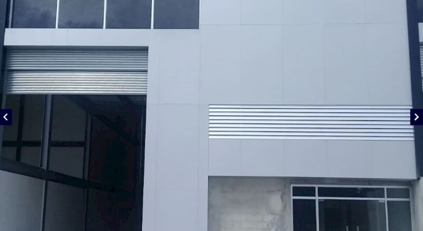 Large industrial rolling doors with vertical glass windows Ofibodegas Milla 8 Panama