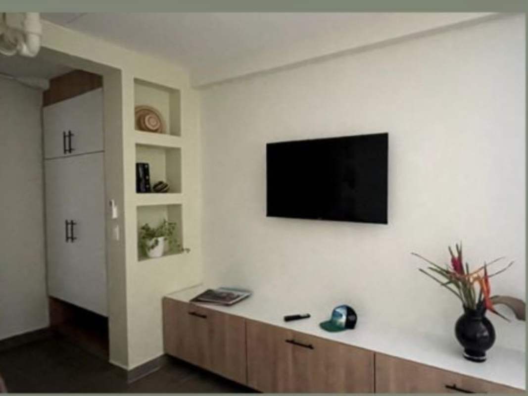 Minimalist living/dining space with mounted TV, window view in PH Albrook Residences Panama City