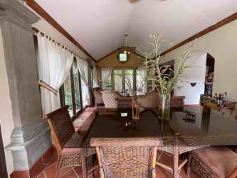 Open-plan tropical living dining area with wicker furniture and garden views Buenaventura Panama