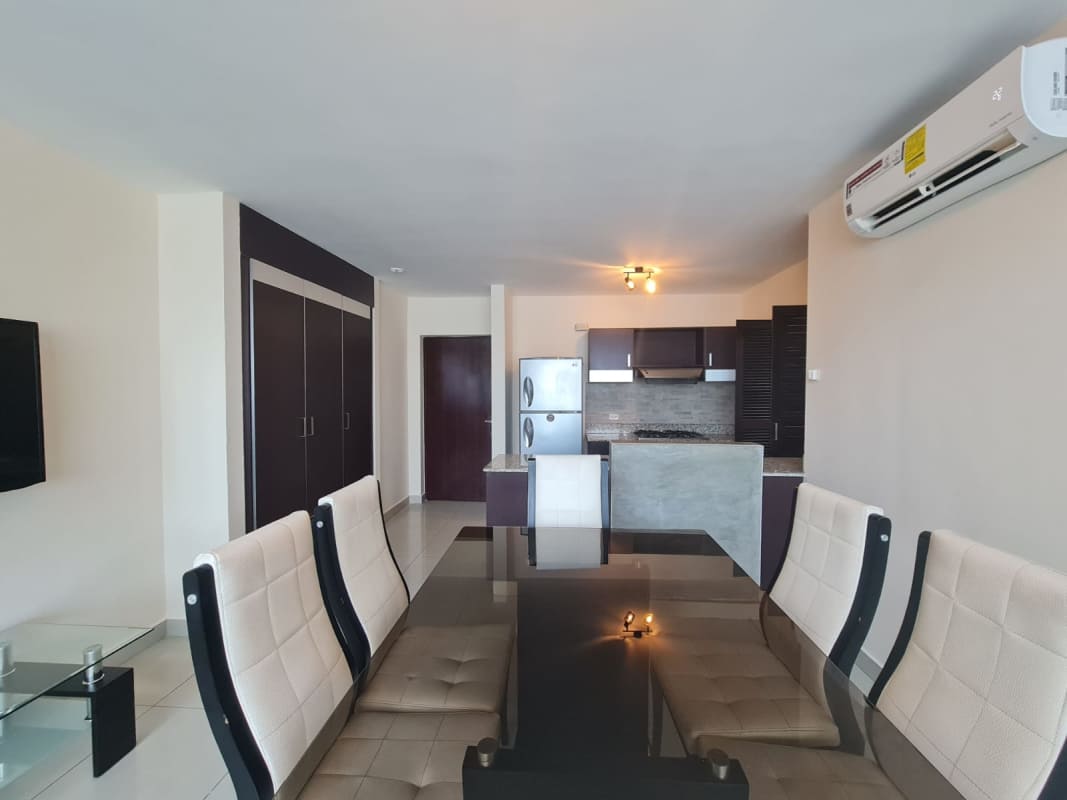 Living space with black sectional sofa and tall windows Vitro Loft Panama