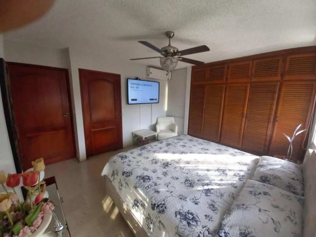 Bedroom with large wardrobes pink bedspread twin windows ceiling fan PH El Carmen Panama