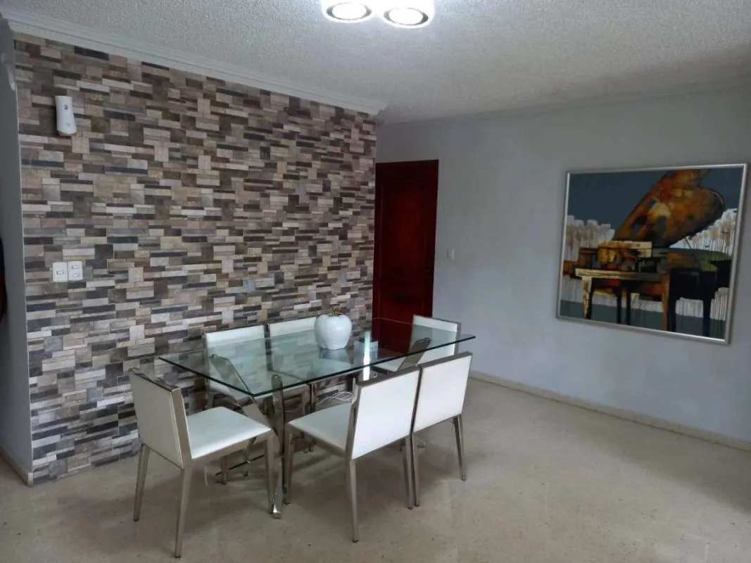 Contemporary dining room with stone accent wall and glass table in PH El Carmen Panama