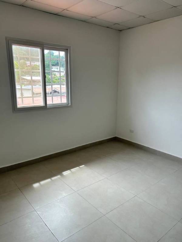 Modern kitchen with tile flooring, dark cabinets, breakfast bar, windows in Betania Panama City house