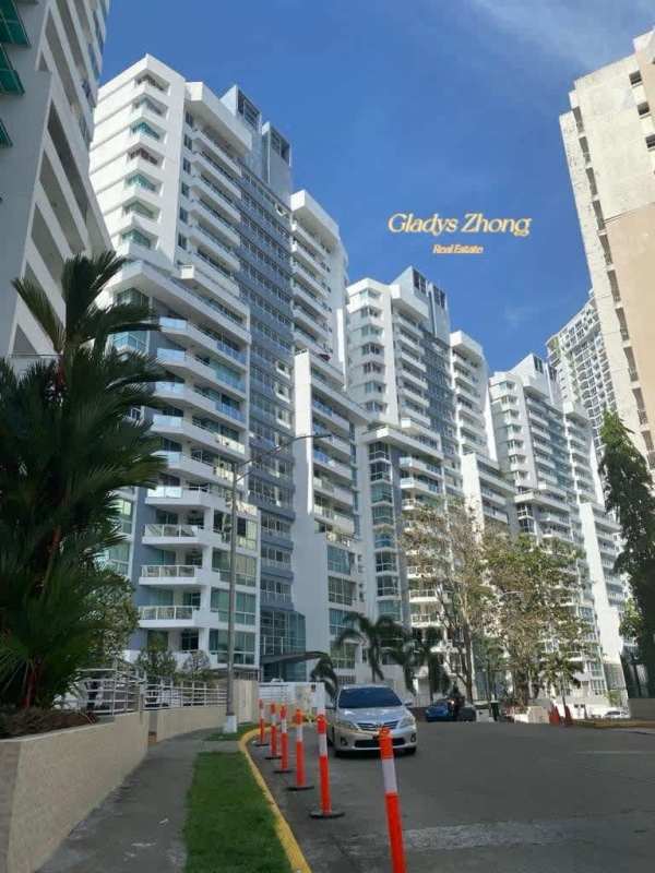 Modern high-rise apartment towers with balconies palm trees and cars at PH El Mare Edison Park Panama City