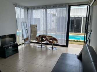 Living area overlooking pool with large windows, minimalist style at Village at The Pool Rio Hato Panama