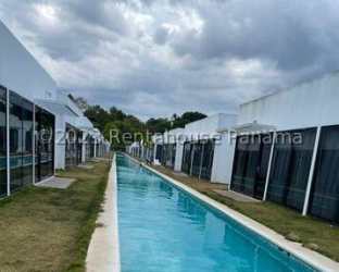 Tropical resort pool area with palapa roof bar, footbridge, palm trees in Village at The Pool Rio Hato Panama