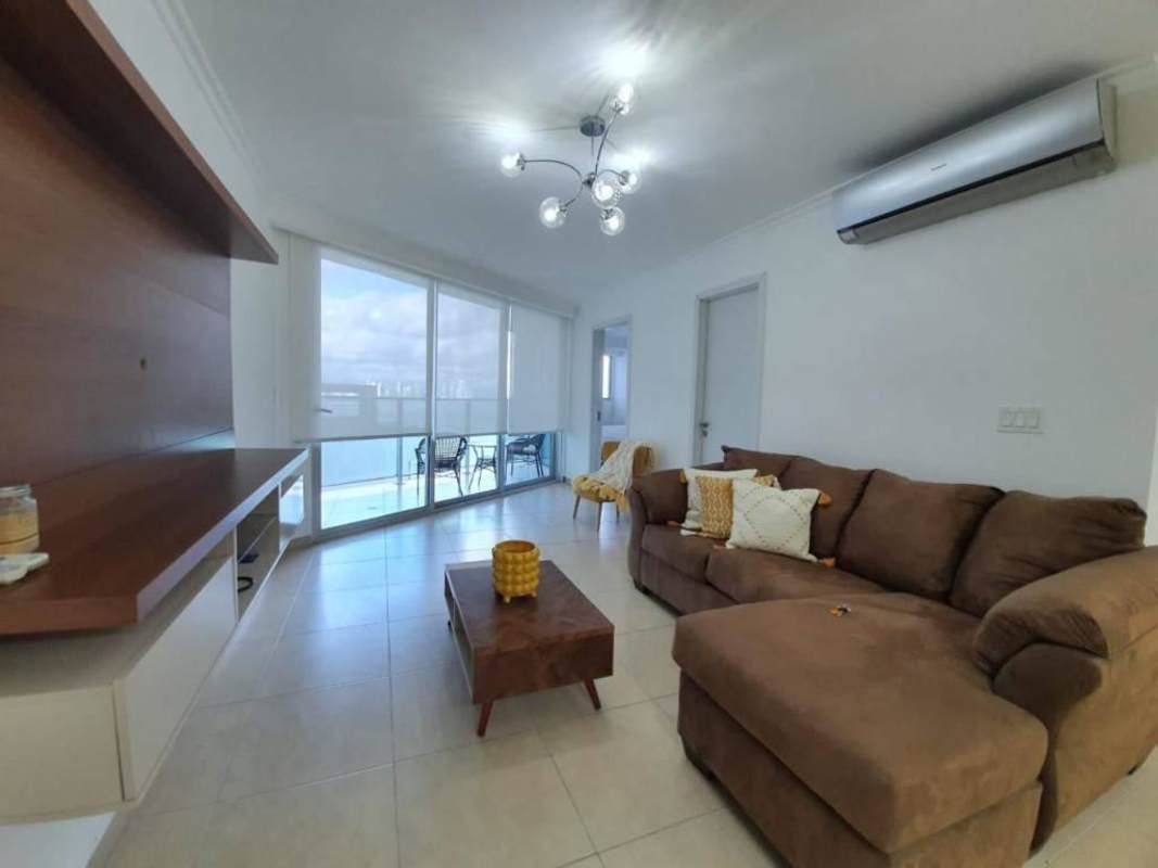 Open living room with sectional sofa and large windows facing the Pacific Ocean in Punta Pacifica