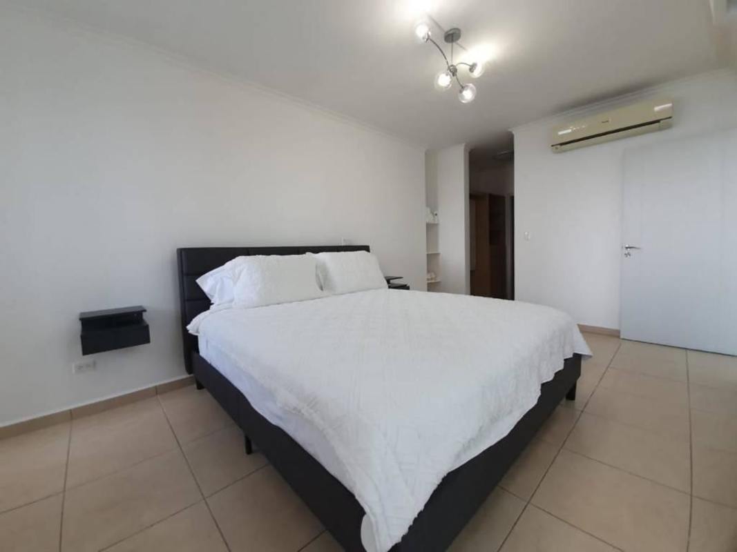 Open-plan modern kitchen with granite counters and bar stools in Punta Pacifica apartment