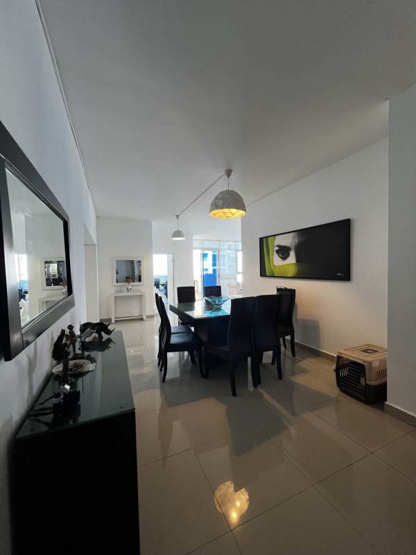 Dining area with glass table and modern pendant lighting in furnished apartment at PH Astoria El Cangrejo