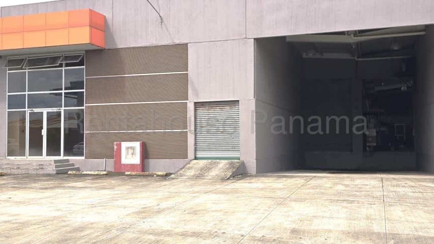Exterior industrial warehouse with glass doors and large metal loading door in Pacora logistics park