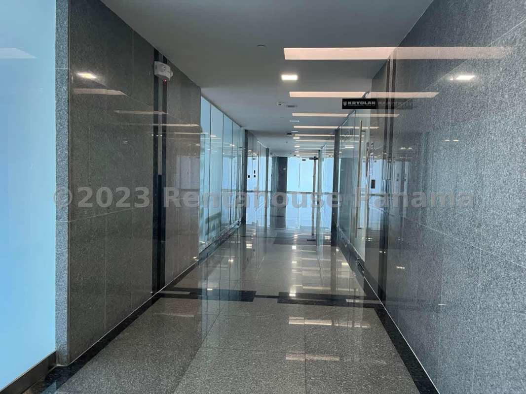 Modern office corridor with granite walls, glass partitions, and elevators in Obarrio