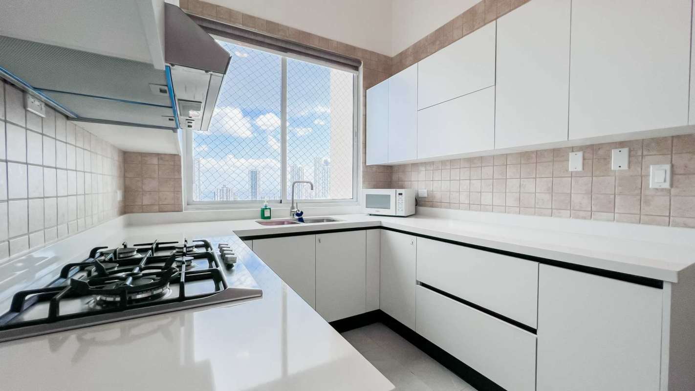 Modern kitchen with panoramic window, granite countertops, gas stove and microwave at PH Costa del Mar Panama