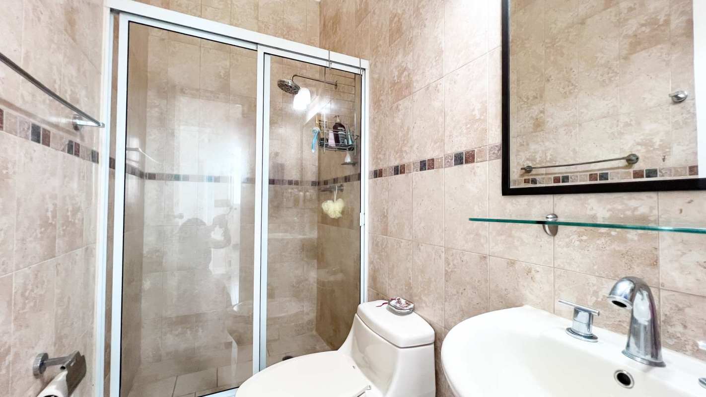 Contemporary full bathroom with glass-enclosed shower, mirror, and modern sink fixtures in PH Costa del Mar apartment rental