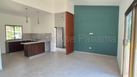 Modern open-plan living dining area with bright windows, teal accent wall and pendant lighting in Villa Guadalupe David