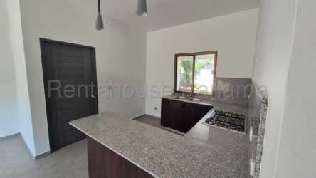 One-story house facade with driveway, stone detail and landscaped yard in David Panama Villa Guadalupe