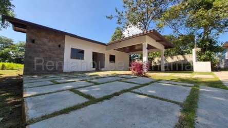 Modern granite kitchen with dining room opening to garden via glass door in David Panama