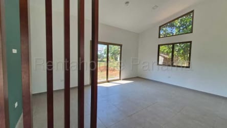 Living room with high ceiling, large windows and teal accent wall in David Panama Villa Guadalupe