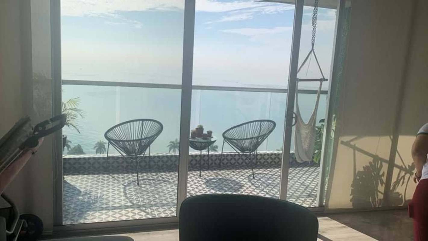 Spacious living dining area with glass doors leading to balcony in BICSA Tower Panama City