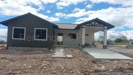 Exterior facade of new single-story bungalow with green details and carport in Grand Canyon Boquete