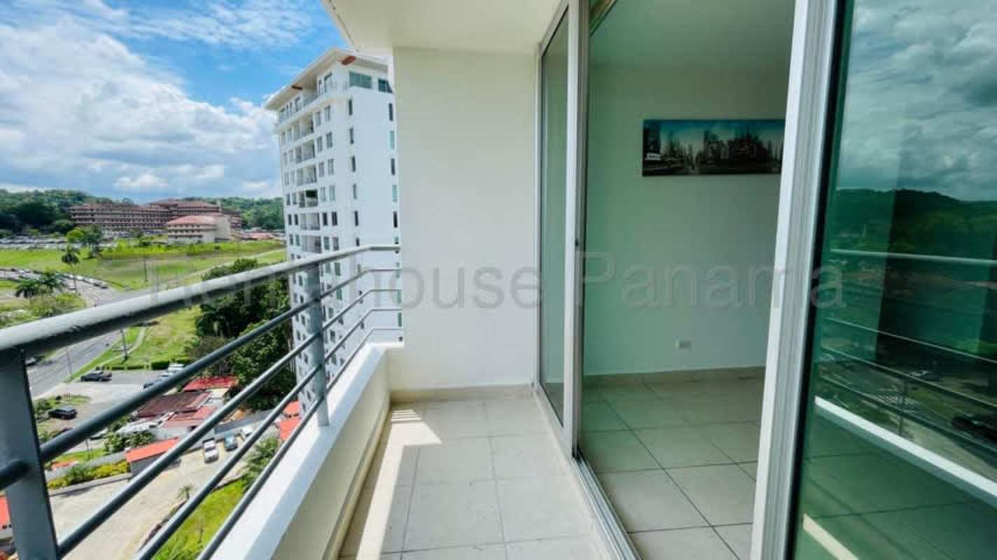Balcony with metal railing overlooking lush gardens and city skyline at PH Clayton Park Panama City