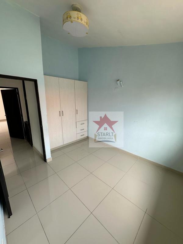 Minimalist bedroom with light blue walls, wardrobe and tiled floor PH Green Village San Miguelito Panama