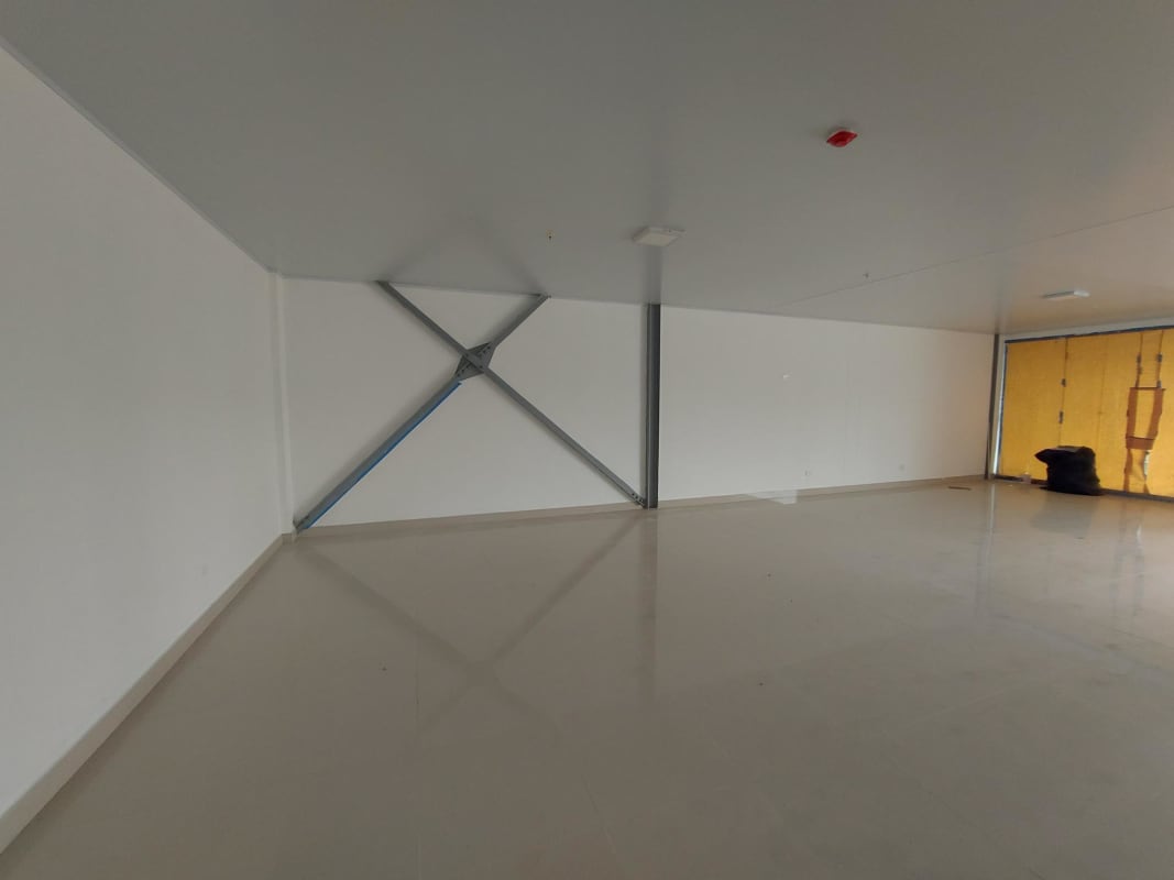 Empty commercial office space with tiled floors, natural light from large glass window in Plaza Dorado Lake Panama City