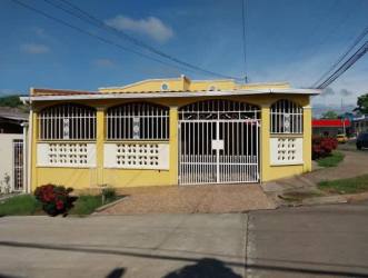 Gated yellow corner house with covered porch in Villa del Carmen Guadalupe La Chorrera