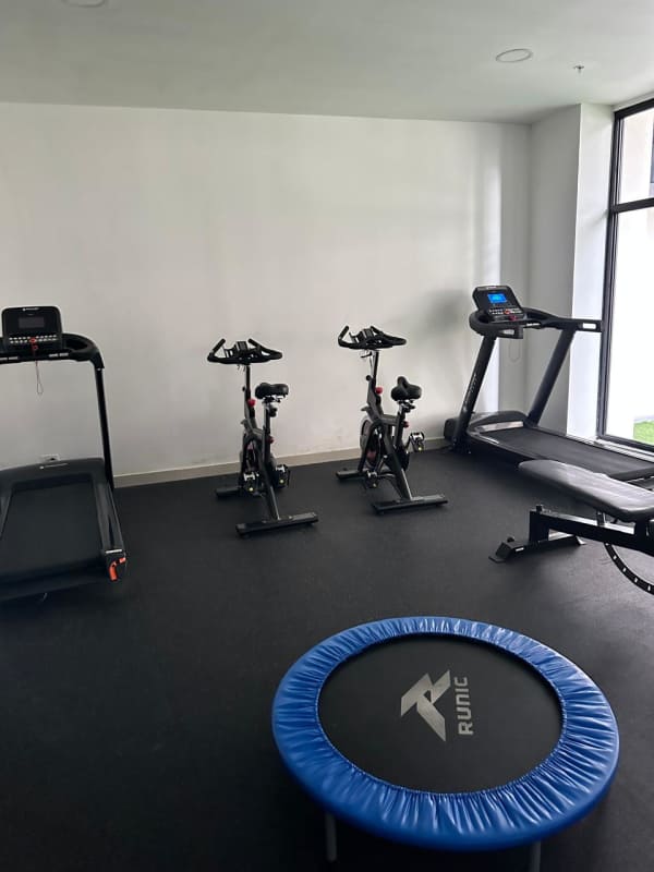 Condominium gym with fitness equipment and large window PH Vía España Tower