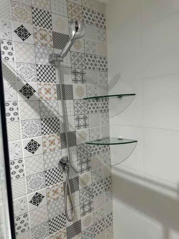 Modern bathroom shower area with patterned tiles and glass shelves Panama